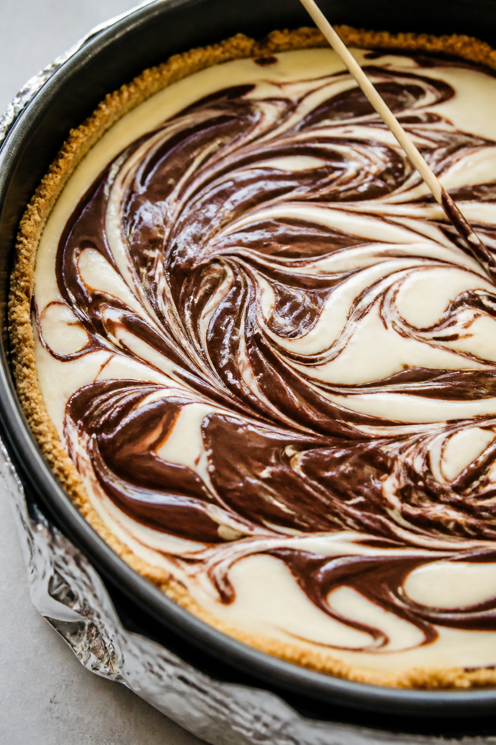 Close-up detail: A just-swirled High Protein Fudge Swirl Cheesecake in a 9-inch springform pan befor