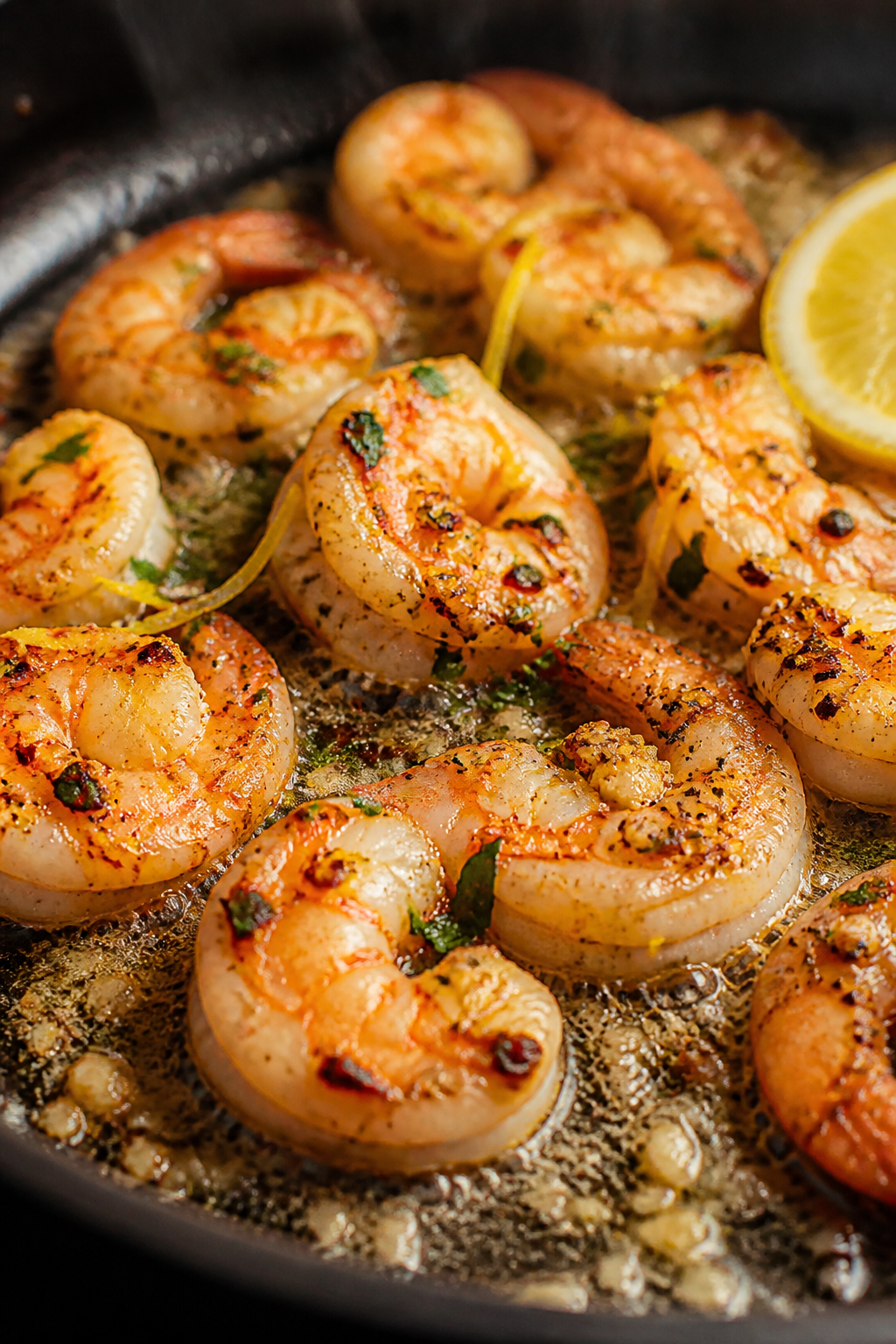 Close-up detail: Sautéed garlic-lemon shrimp in a skillet mid-cook, shrimp just opaque and pink wit