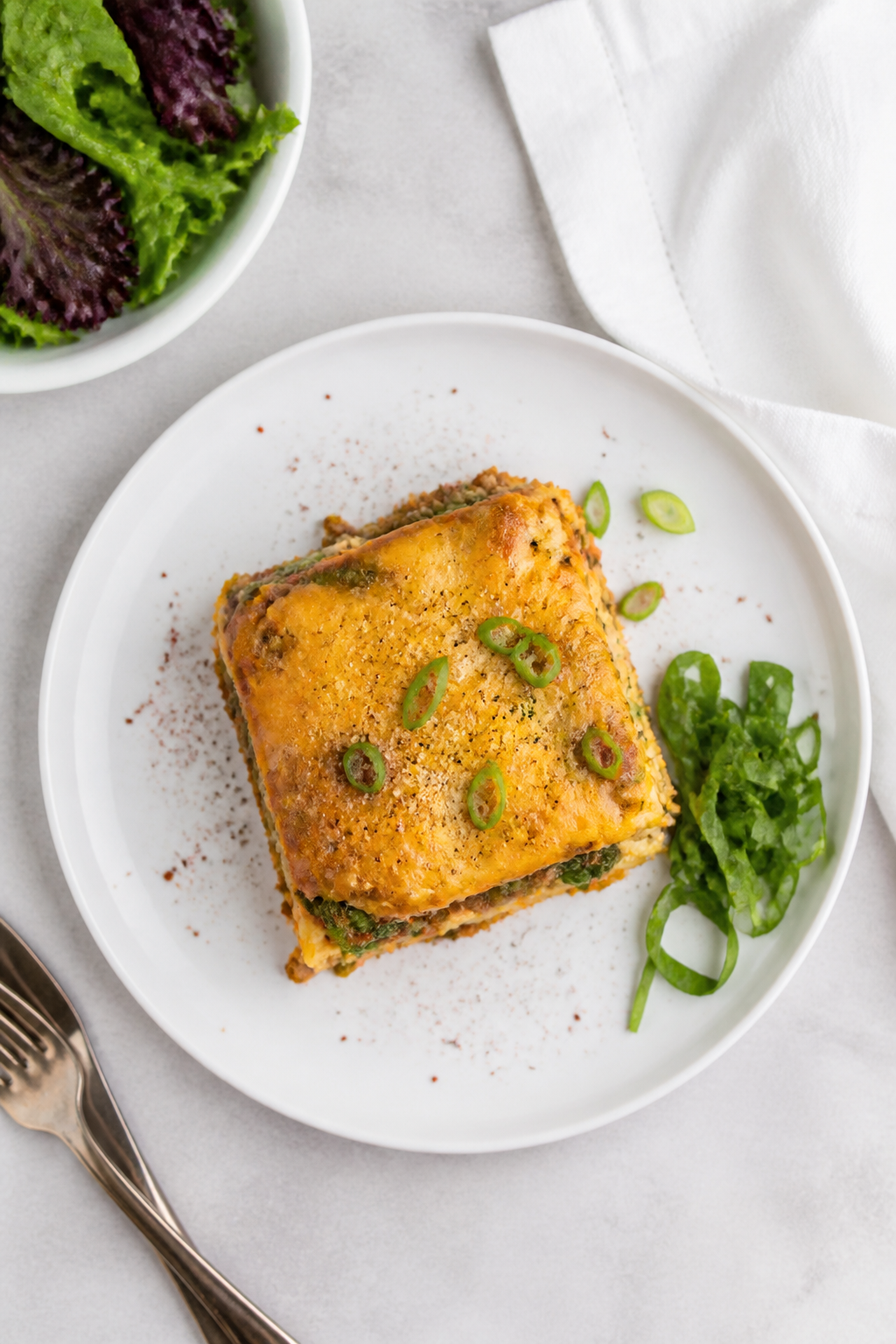 Final plated dish, overhead: Restaurant-quality serving of the hamburger casserole on a matte white 