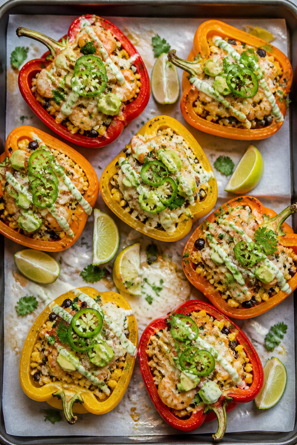 Overhead shot of shrimp taco stuffed peppers fresh from the oven: halved red, yellow, and orange bel