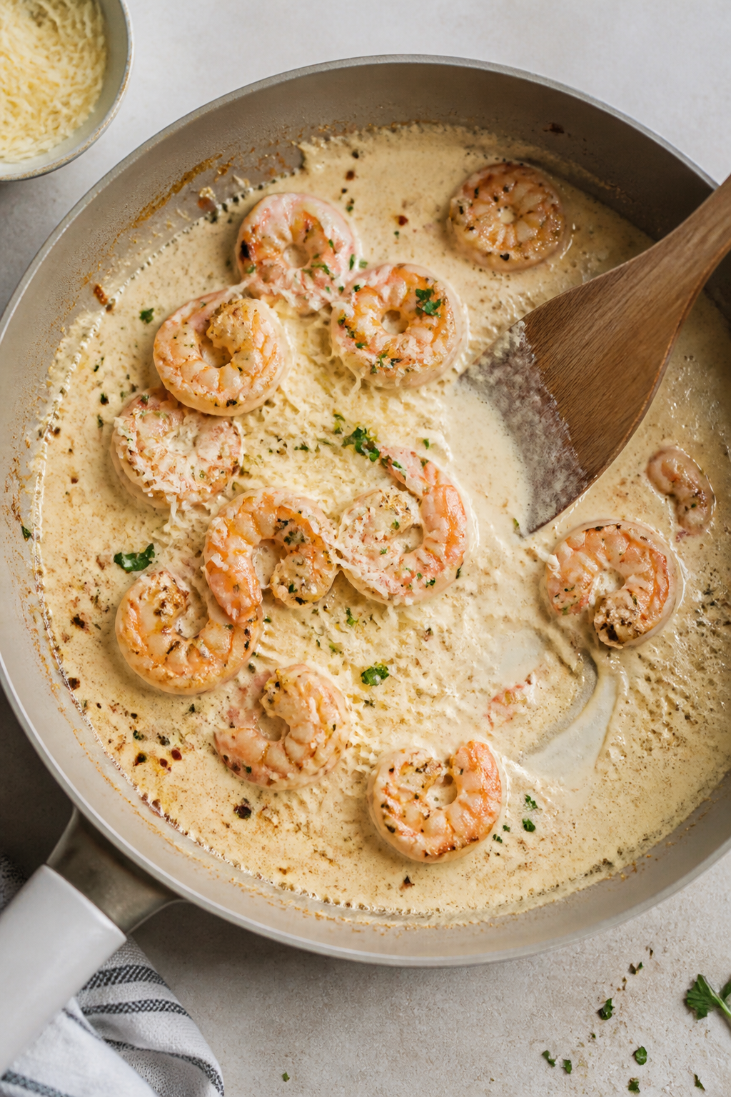 Sauce-building moment, overhead tasty top view: Creamy garlic-Parmesan sauce in a skillet at a gentl