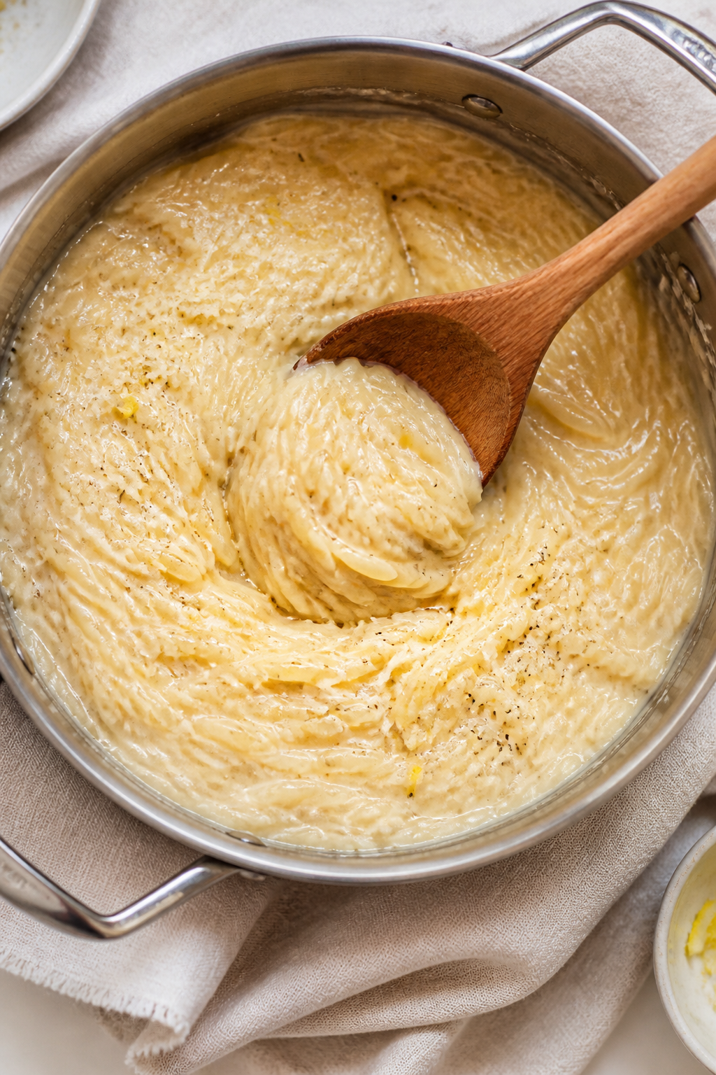 Tasty top view: Overhead shot of creamy Parmesan orzo in a saucepan, glossy and risotto-like, with v