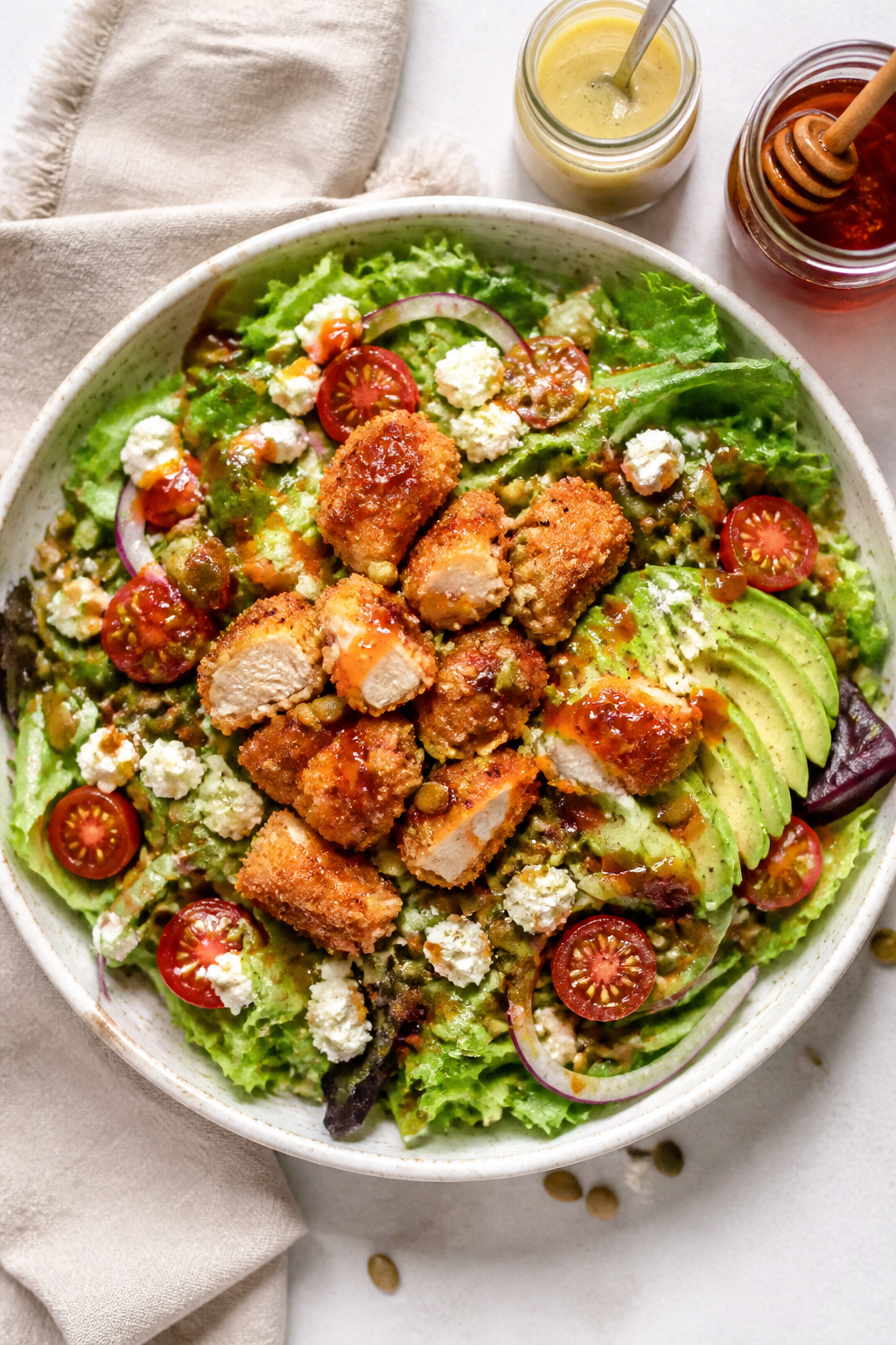 Tasty top view: Overhead shot of the assembled Crispy Hot Honey Chicken Salad in a wide, shallow cer
