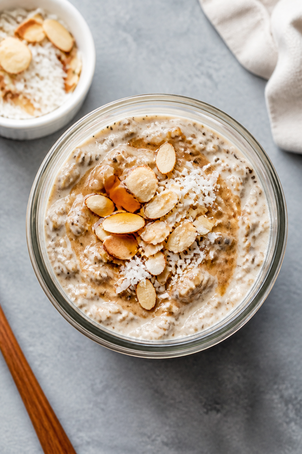 Overhead jar assembly shot: Tasty of Coconut Almond Protein Overnight Oats right after an overnight