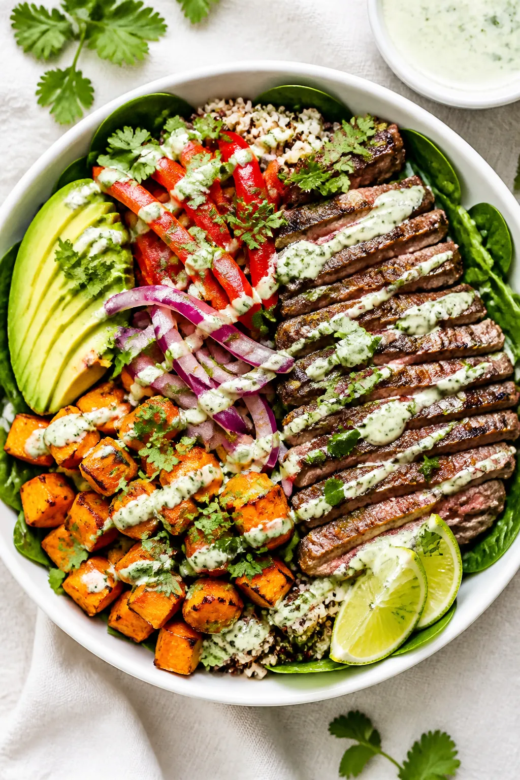Tasty top view: Overhead shot of assembled High Protein Steak and Sweet Potato Bowls—greens (baby 