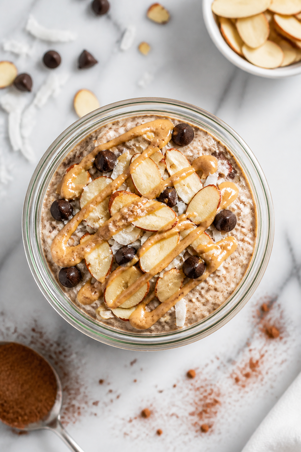 Tasty top view: Overhead shot of the finished Almond Joy overnight oats in a clear glass jar, topped